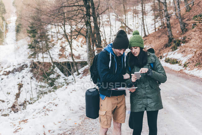 Пішохідна пара дивиться на смартфон — стокове фото
