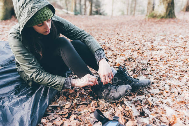 Hiker putting on hiking boots in forest — Stock Photo