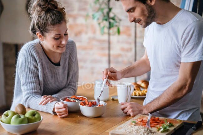 Couple eating fruit breakfast at counter — Stock Photo