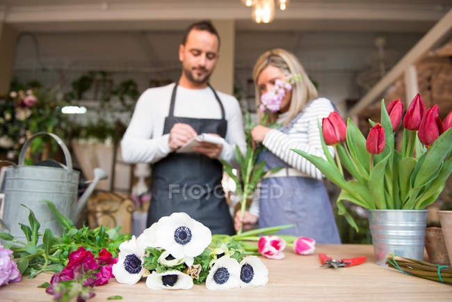 Dois floristas preparando ordem de flores — Fotografia de Stock