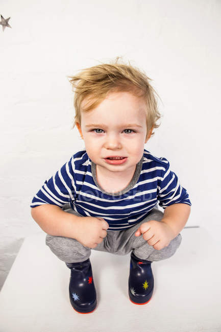 Kleinkind kauert auf Spielzeugkiste — Stockfoto