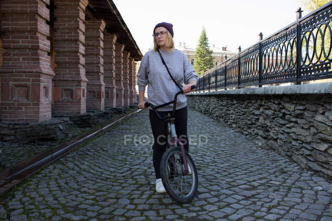 Mujer joven con bicicleta BMX - foto de stock