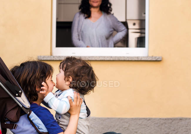 Женщина смотрит на сыновей — стоковое фото