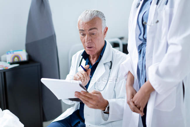 Arzt schaut sich medizinische Diagramme an — Stockfoto