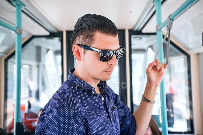 Jovem de pé no ônibus — Fotografia de Stock