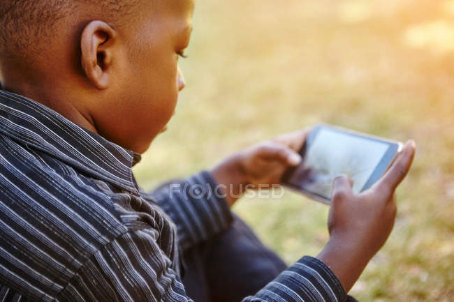 Хлопчик грає в гру на мобільному телефоні — стокове фото