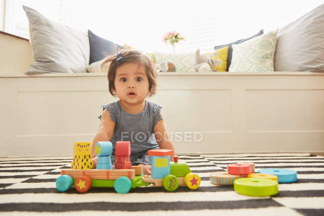 Bébé fille assis sur tapis — Photo de stock