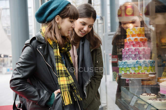 Жінки дивляться на вікно магазину торта — стокове фото