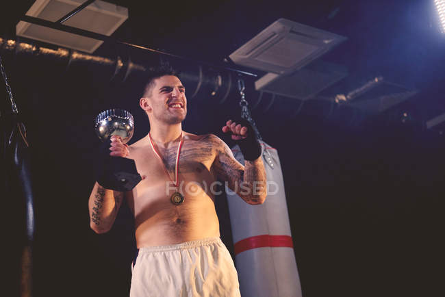 Campeón de boxeo sosteniendo trofeo - foto de stock