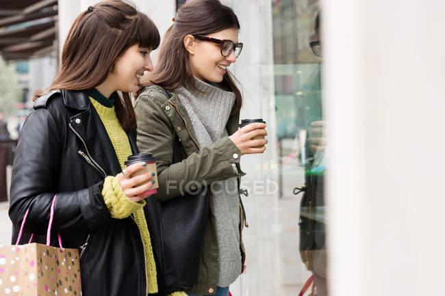 Two young female looking in window — Stock Photo