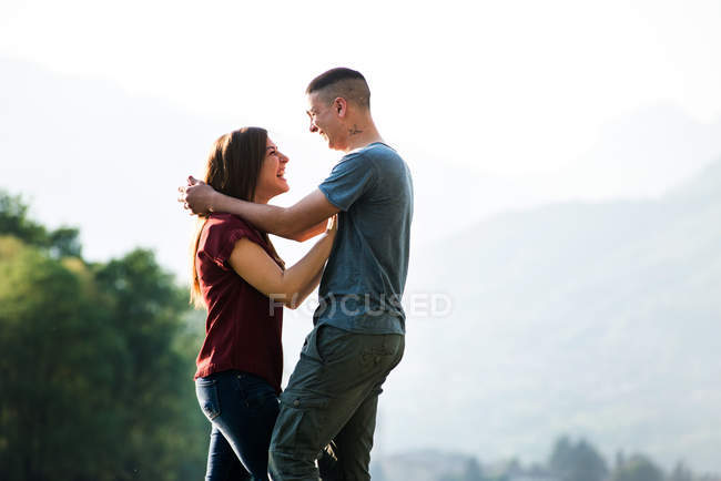 Couple standing outdoors and hugging — Stock Photo