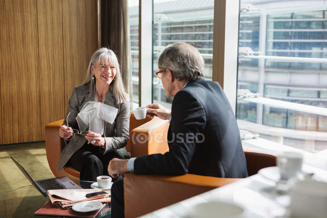 Businessman and businesswoman in coffee area in office — Stock Photo