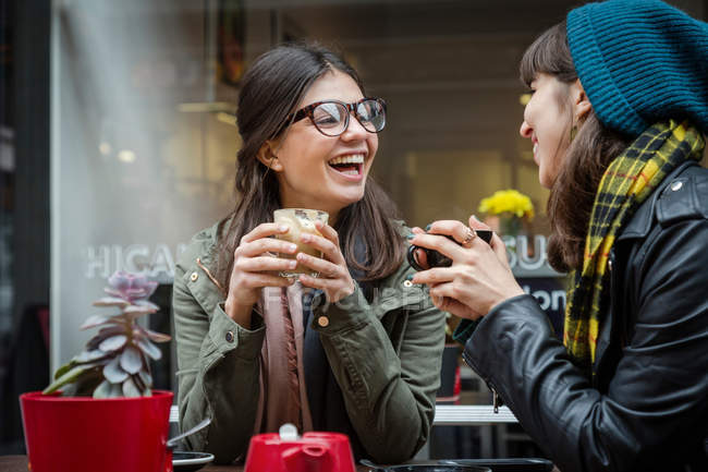 Young women at sidewalk cafe — Stock Photo