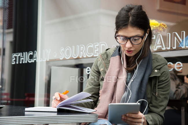 Молода жінка дивиться на цифровий планшет — стокове фото