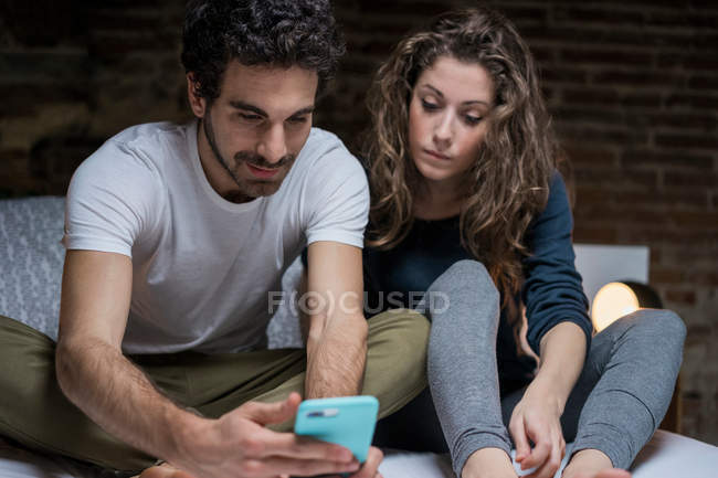 Пара глядя на смартфон — стоковое фото