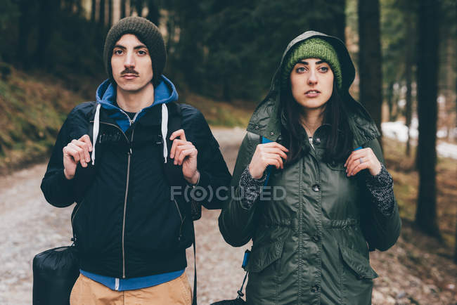 Hiking couple wearing knit hats in forest — Stock Photo