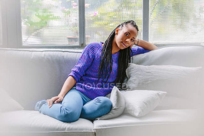 Retrato de la mujer sentada en el sofá - foto de stock