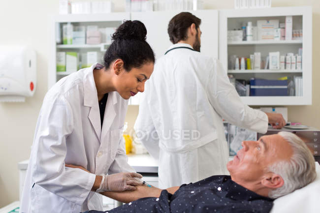 Doctor extracting patients blood — Stock Photo