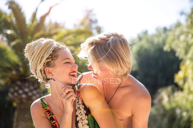 Rire couple blond au bord de la piscine — Photo de stock