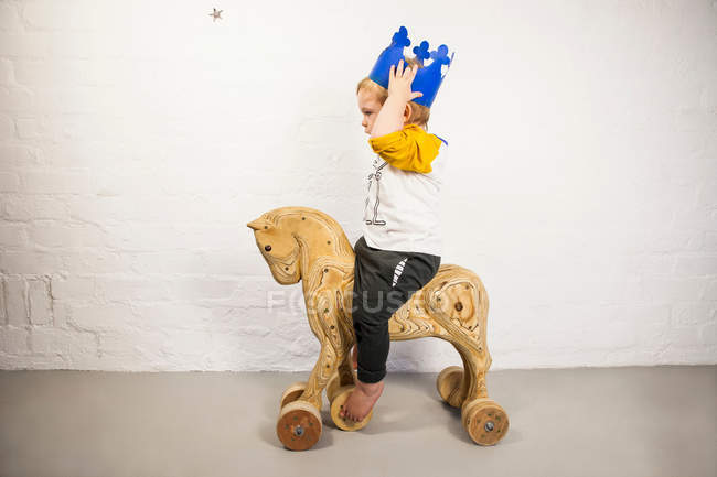 Male toddler sitting on toy horse — Stock Photo