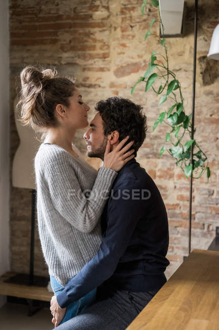 Couple s'embrassant au comptoir de la cuisine — Photo de stock