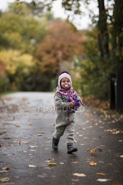 Fille en costume tricoté jouant à l'extérieur — Photo de stock