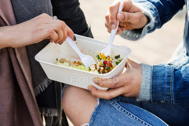 Mulheres jovens compartilhando comida takeaway — Fotografia de Stock