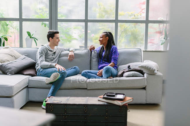 Couple sitting on sofa talking — Stock Photo