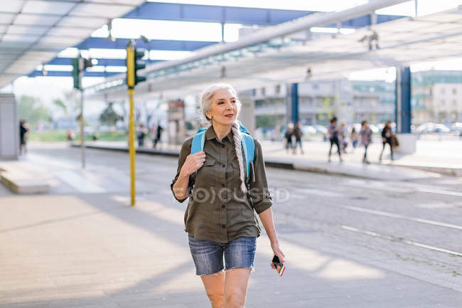 Zaino in spalla femminile a piedi nella stazione degli autobus — Foto stock