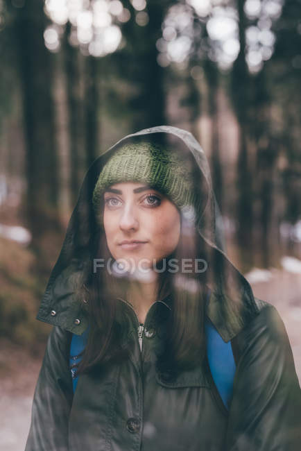 Female hiker wearing knit hat in forest — Stock Photo