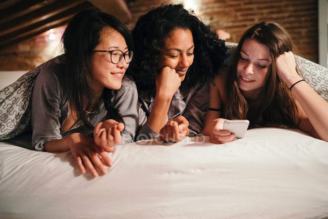 Friends lying on bed — Stock Photo