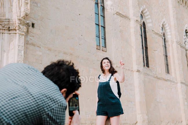 Mann fotografiert Freundin vor der Kathedrale von Arezzo — Stockfoto