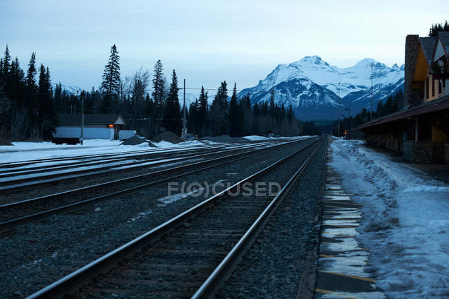 Trilhos ferroviários com montanhas no fundo — Fotografia de Stock