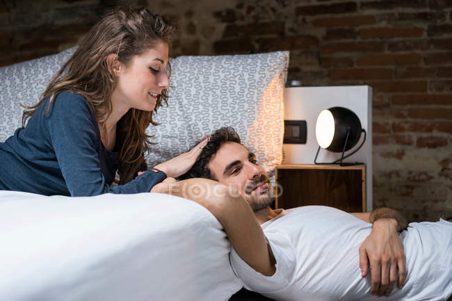 Couple reclining on bed — Stock Photo