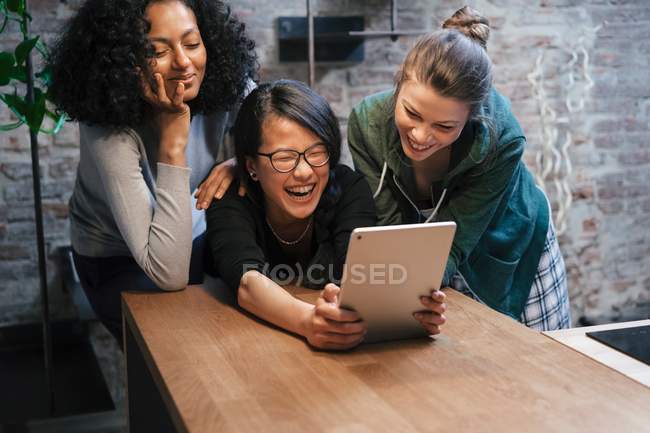 Friends using digital tablet — Stock Photo