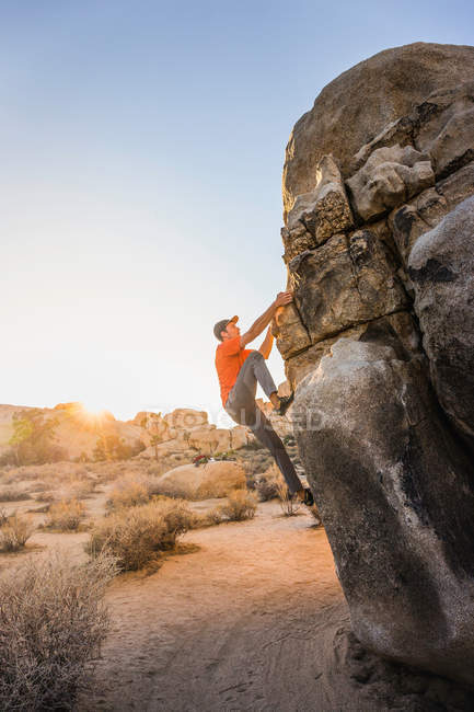 Male boulderer moving up boulder — Stock Photo