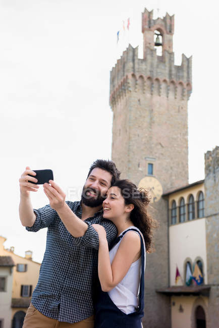 Couple taking selfie by Arezzo Cathedral — Stock Photo