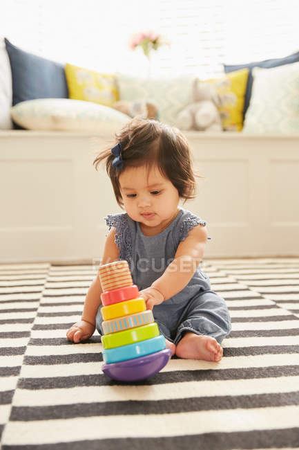 Дівчинка сидить на килимку — стокове фото