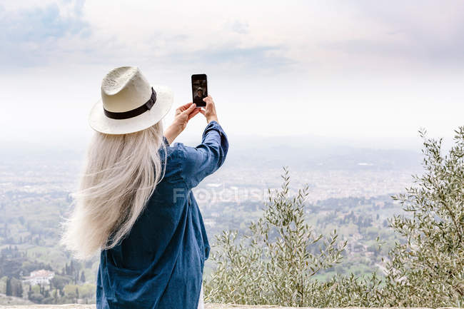 Жінка з довгими сивим волоссям фотографування подання — стокове фото
