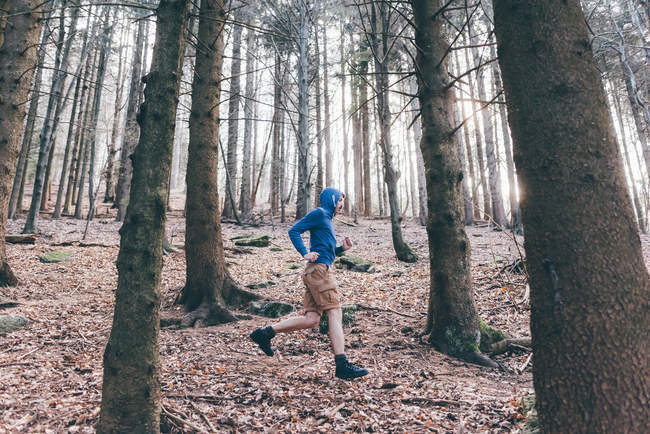 Corredor masculino correndo em floresta íngreme — Fotografia de Stock