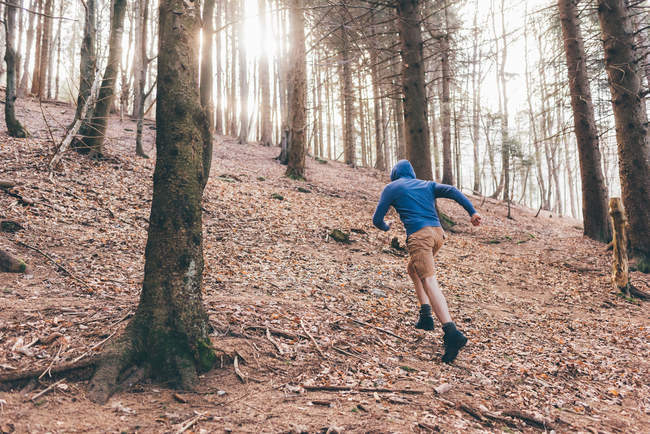 Чоловік бігун біжить крутим лісом — стокове фото