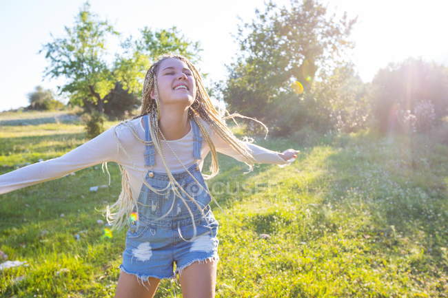 Woman with long plaited blond hair running in field — Stock Photo