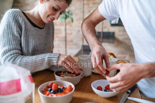 Pareja preparando el desayuno juntos - foto de stock