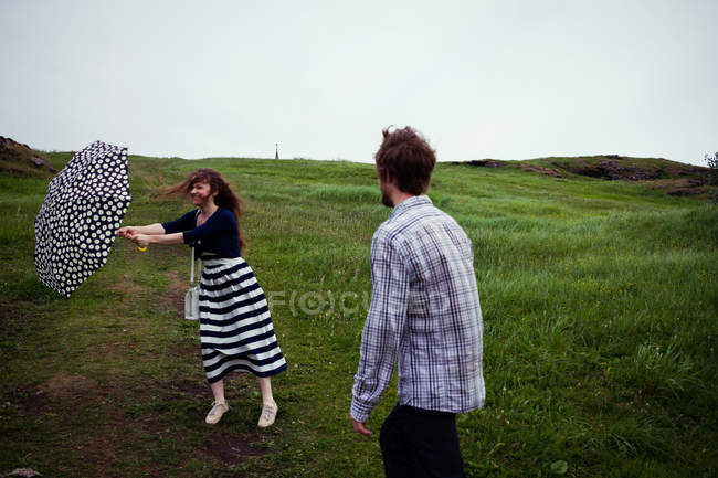 Couple standing in field on windy day — Stock Photo