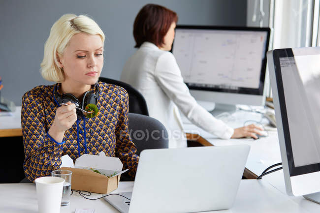 Diseñador femenino mirando el ordenador portátil - foto de stock