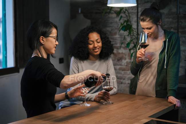 Amici che condividono bottiglia di vino rosso — Foto stock
