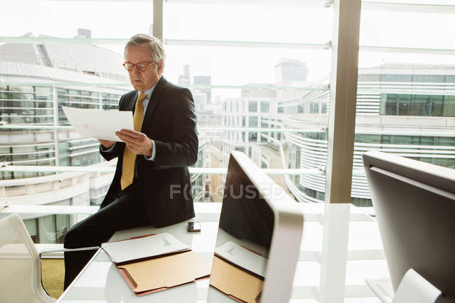 Un homme d'affaires lisant et analysant un rapport — Photo de stock