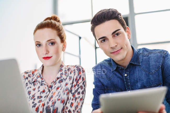 Colleagues using digital tablet and laptop — Stock Photo