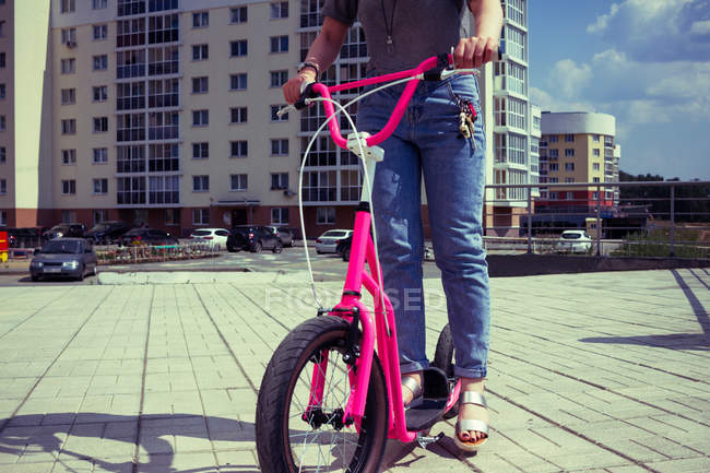 Mujer en scooter rosa - foto de stock