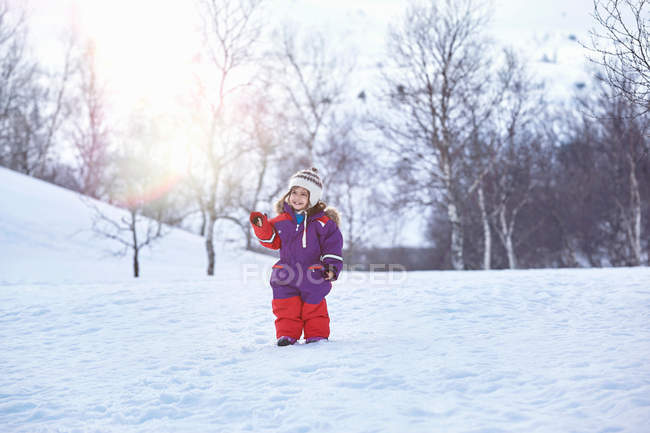 Chica, de pie en el paisaje nevado - foto de stock